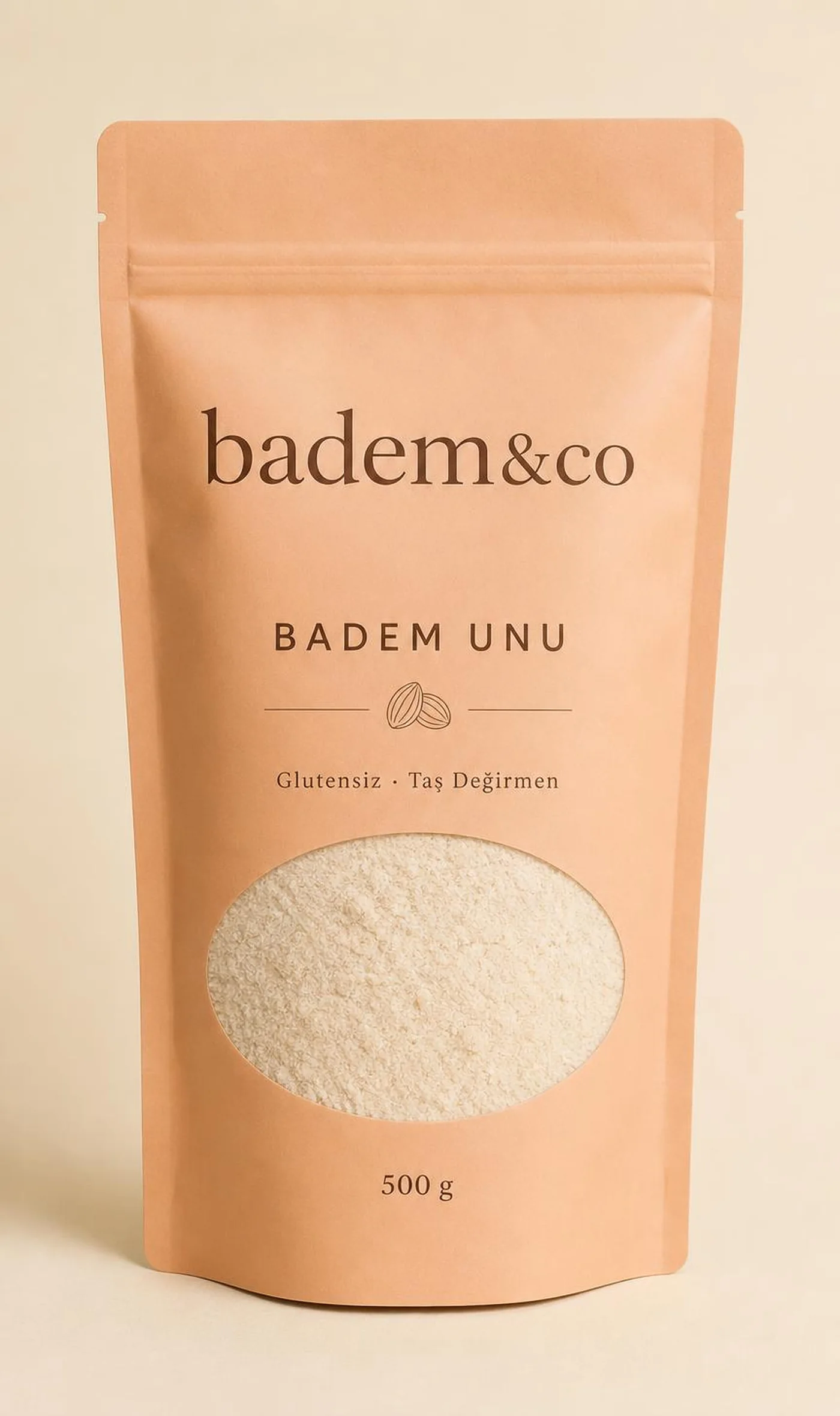 Badem Unu 500 g kilitli kraft doypack paketinin ön yüzü: "badem&co" logosu, "BADEM UNU" ürün adı, "Glutensiz · Tek malzeme" tanımı ve glutensiz ibaresi ile öğütme tarihi alanı